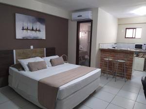 ein Schlafzimmer mit großem Bett und eine Küche in der Unterkunft Marsallis Praia - Flat 404 - Vista Mar in Natal