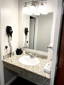 a bathroom with a sink and a mirror at Dunes Motel Hillsboro in Hillsboro