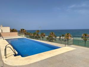 a swimming pool with the ocean in the background at Casa Dru in Roquetas de Mar