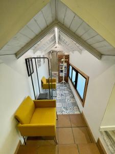 a living room with a yellow couch and chairs at Casa Susa in Poio