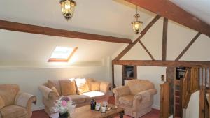 a living room with two chairs and a table at Shepherd's Watch Cottage - 5* Cyfie Farm with private hot tub in Llanfyllin