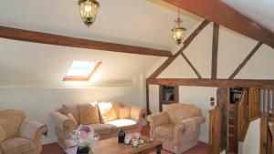 un soggiorno con due sedie e un tavolo di Shepherd's Watch Cottage - 5* Cyfie Farm with private hot tub a Llanfyllin