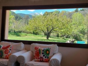a large window in a living room with two white couches at Puente Canto de Gredos in Arenas de San Pedro
