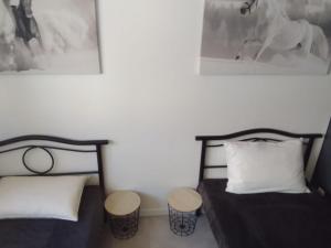 two twin beds in a room with two pictures on the wall at Résidence Les Hauts de France in Noeux-les-Mines