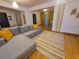 een woonkamer met een grijze bank en gele kussens bij Upground14 Residence Apartments in Boekarest