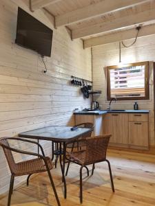 a dining room with a table and two chairs at Domki Pod Dębami in Pobierowo