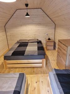 a bedroom with a bed in a wooden room at Domki Pod Dębami in Pobierowo