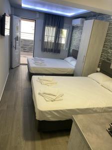 Habitación con 3 camas en una habitación con encimera en Vila Savic, en Olympiakí Aktí