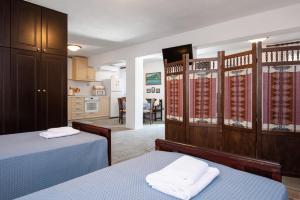 a bedroom with two beds and a kitchen at Sifnos' Green and Blue in Sifnos