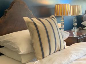 a bed with white pillows and a wooden head board at The Coast Yard B & B and Garden Chalets in Chichester