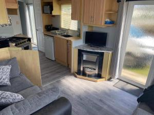 a kitchen with a living room with a fireplace at Legacy on Highfields in Skegness