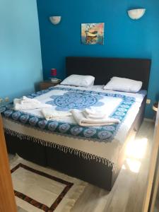 a bedroom with a bed with a blue wall at Arte Casa in Burgas City