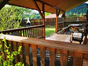 a wooden deck with a table and a picnic table at Pokoje Gościnne Agnes in Sanok