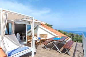 a balcony with a table and chairs and a view of the ocean at Summer House Bougainvillea by Dubrovnik Colors in Blato