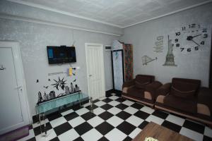 una sala de estar con 2 sofás y un reloj en la pared en Hostel California en Batumi