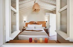 a bedroom with a bed and two windows at Skiathos Villa Ira in Koukounaries