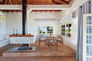 a living room with a fireplace and a table at Skiathos Villa Ira in Koukounaries +49 photos