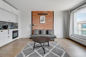 un soggiorno con divano e muro di mattoni di Downtown Apartments Seaside Przystań Letnica a Danzica
