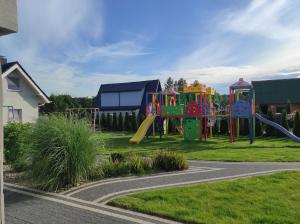 a colorful playground in a yard with afficientfficientfficientfficientfficientfficient at Ośrodek Wypoczynkowy Domki Nadika in Bobolin