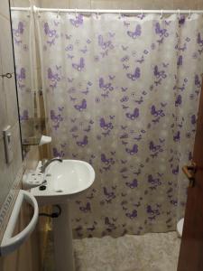 Un baño con lavabo y cortina de ducha. en Ankara 1, en Las Grutas