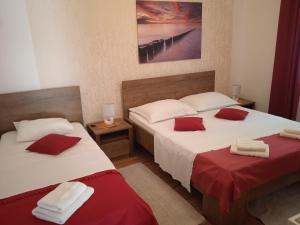 a bedroom with two beds with red and white sheets at Villa Marin in Pag +66 photos