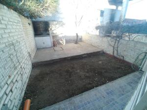 un patio trasero con una pared de ladrillo y un patio de tierra en Ankara 1, en Las Grutas
