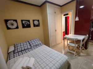 una camera con letto, scrivania e tavolo di Estudio Lorenzo Acogedor a Madrid