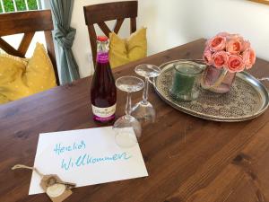 a table with a bottle of wine and glasses and flowers at Ferienwohnung mit Charme in Eurasburg