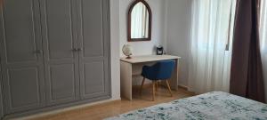sypialnia z biurkiem, łóżkiem i niebieskim krzesłem w obiekcie Beautiful garden flat nearly refurbished free WiFi w Corralejo