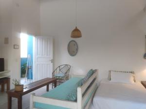 a bedroom with two beds and a clock on the wall at LOFT Luz Solar Buzios in Búzios