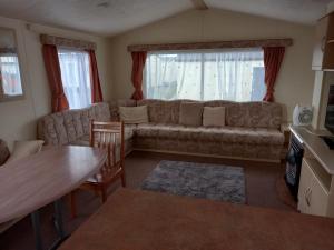 a living room with a couch and a table at Holiday Home in Lyons Robin Hood Holiday Park in Meliden