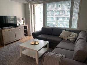 a living room with a couch and a coffee table at Modern one bedroom apartment nearby Airport in Vantaa