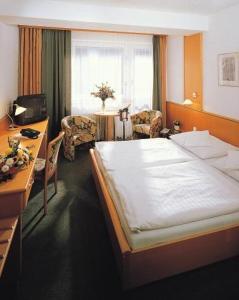 a bedroom with a large bed and a desk and a desk at Hotel Monica in Prague