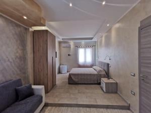 a bedroom with a bed and a couch and a window at Villa Bianca in Chia
