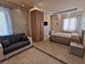 a bedroom with a bed and a couch and a tv at Villa Bianca in Chia