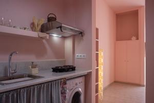 a kitchen with a sink and a washing machine at Ann's apartment II in Lixouri