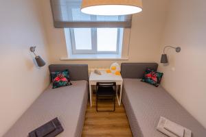 twee bedden in een kamer met een tafel en een raam bij Apartment near Baltic Sea 2 in Jūrmala