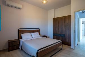 a bedroom with a bed and a wooden cabinet at Sugar Stone House in Pyrgos Dirou
