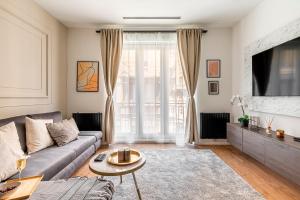 a living room with a couch and a tv at Asboth Boutique Budapest in Budapest