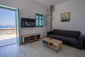 a living room with a couch and a view of the ocean at Sugar Stone House in Pyrgos Dirou
