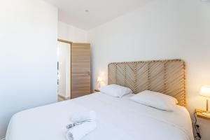 - une chambre avec un lit blanc et 2 serviettes dans l'établissement Marseille: Superbe vue sur Notre-Dame de la Garde, à Marseille