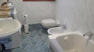 a white bathroom with a toilet and a sink at Appartamento Campitello House in Campitello di Fassa +22 photos
