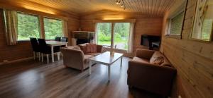 a living room with couches and a table in a cabin at Døskeland in Sande