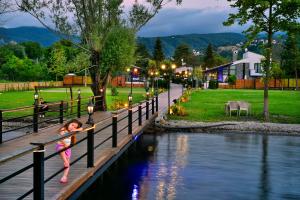 una niñita parada en una cerca al lado de un río en Nibras Villa Resort Hotel en Sapanca