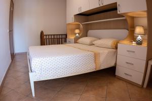 um quarto com uma cama grande e uma cabeceira em madeira em Casa di Franco em Alba Adriatica