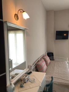 a small room with a mirror and a bed at Spyridonou House in Parga