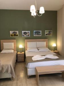 two beds in a bedroom with green walls at Spyridonou House in Parga