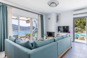 a living room with a couch and a large window at Ninemia Villa in Skopelos in Skopelos Town