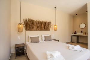 een slaapkamer met een groot wit bed en 2 handdoeken bij Atma Beach Rooms & Suites in Faliraki