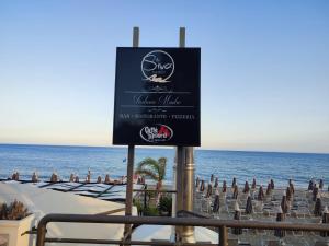 un cartel en una playa con sillas y el océano en Casa SoleMare a pochi passi dalla spiaggia di Terracina, en Terracina